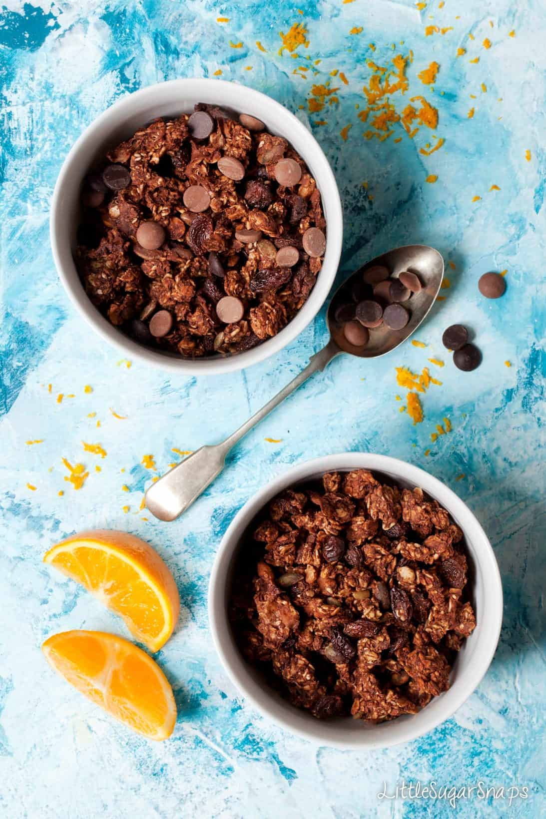 Servings of Chocolate Orange Granola in bowls with milk and dark choc chips.