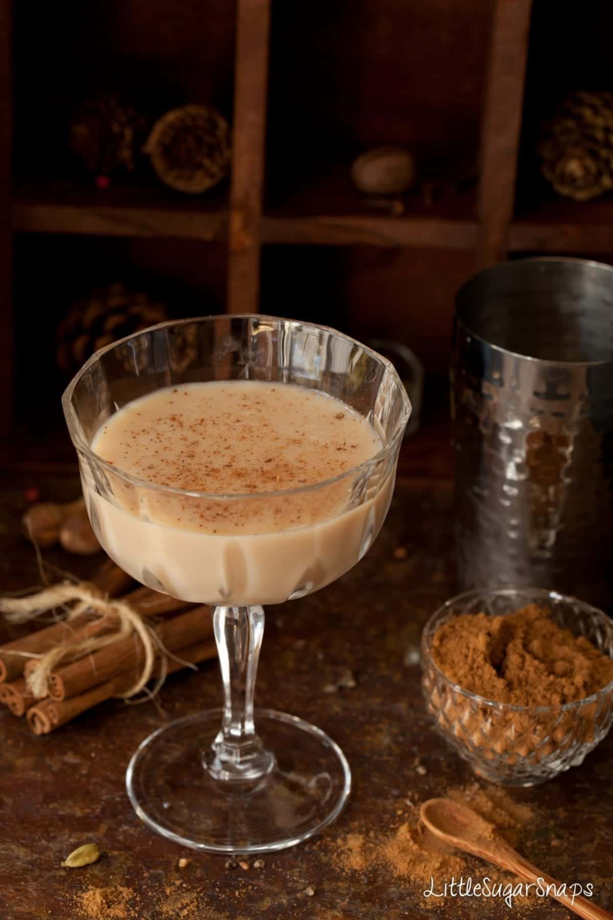 A glass of chai spiced latte martini with ground spice on top 