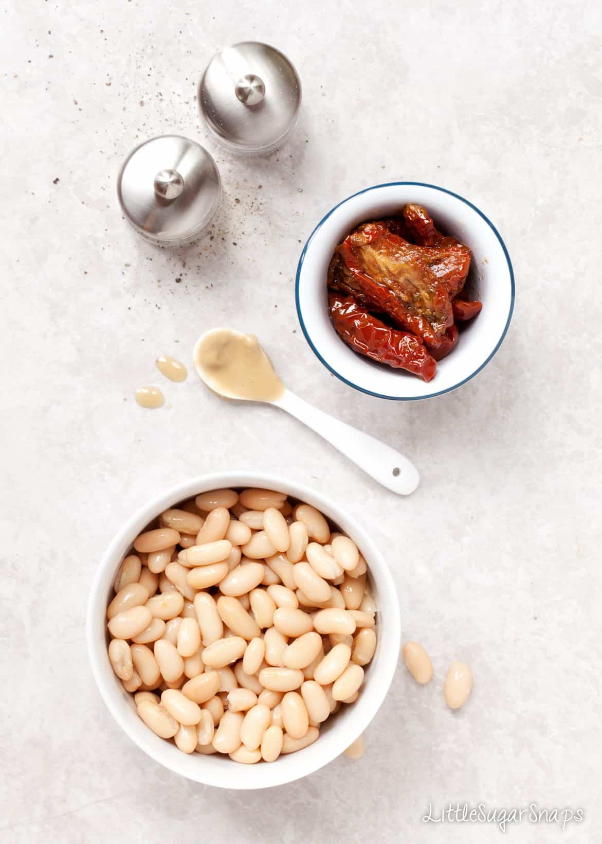 White beans and sundried tomatoes in bowls.