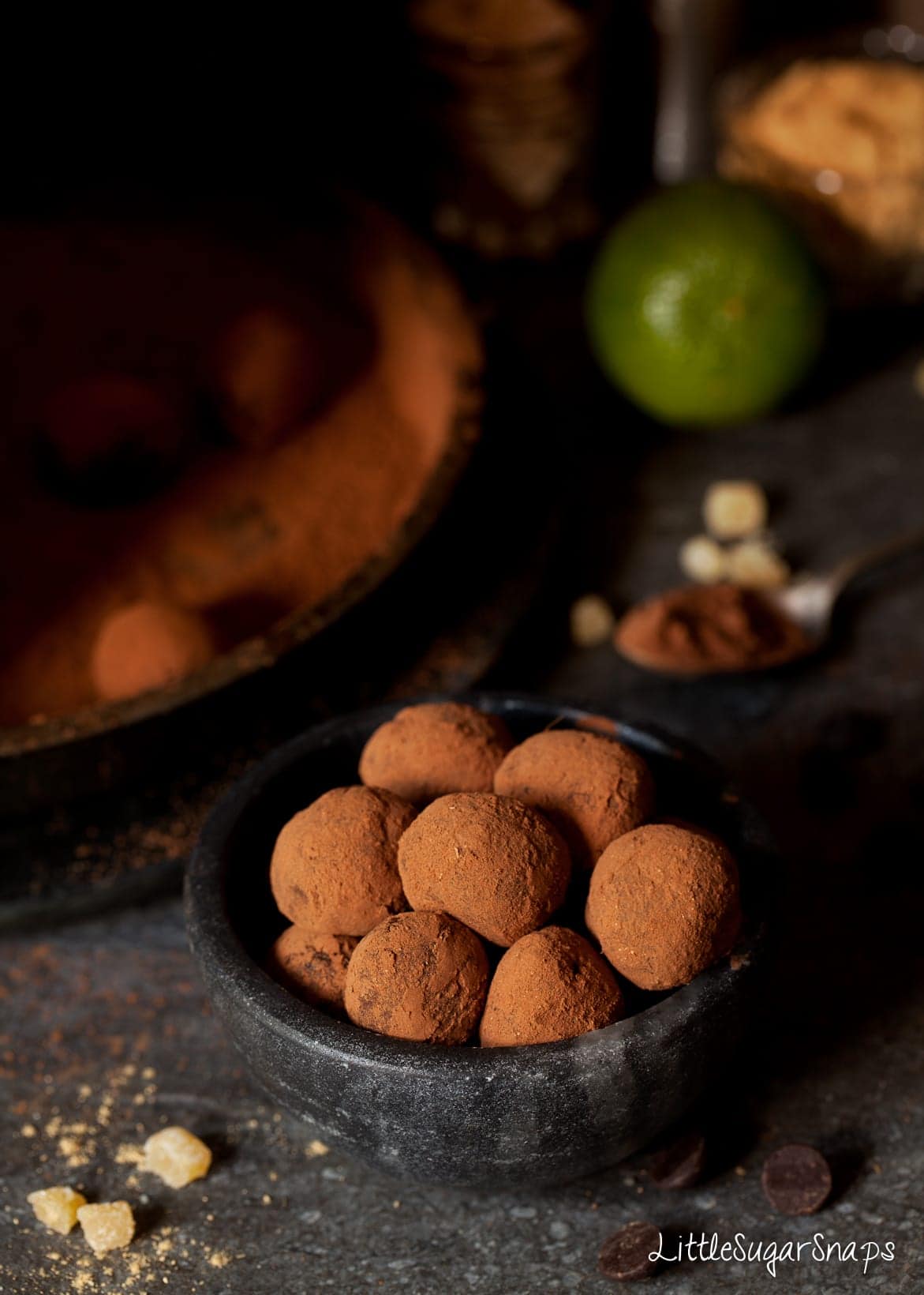 A bowl of chocolate ginger truffles with crystallised ginger alongside.