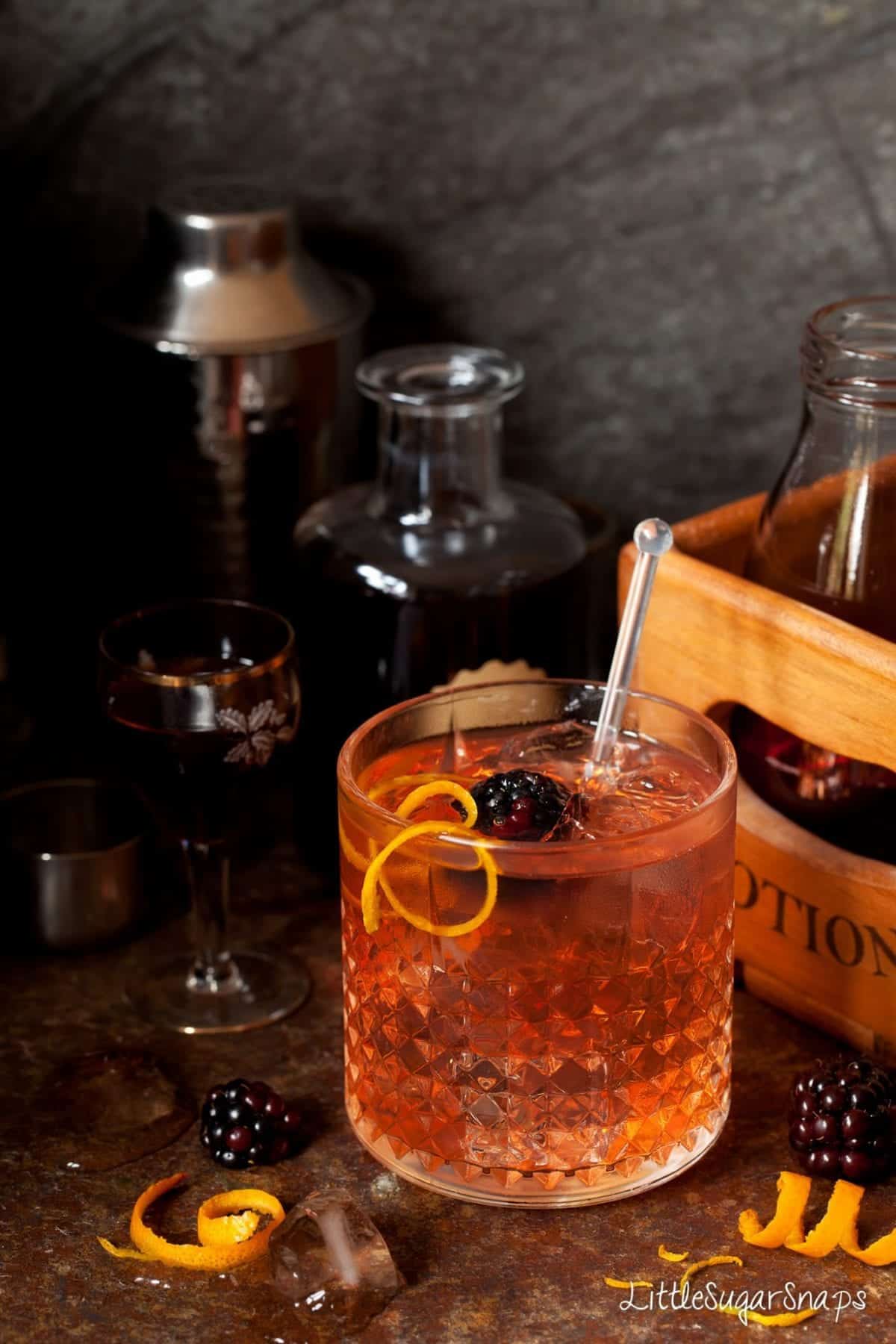 Winter Gin & Tonic with campari & sloe gin garnished with blackberry and orange peel.