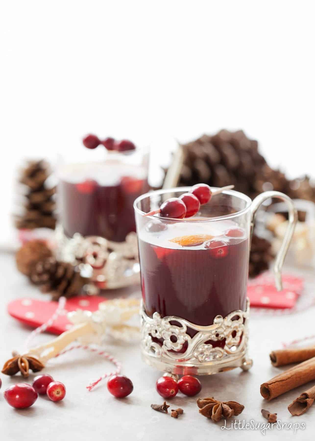 Mulled Grape Juice in a vintage glass mug with fresh cranberry garnish.