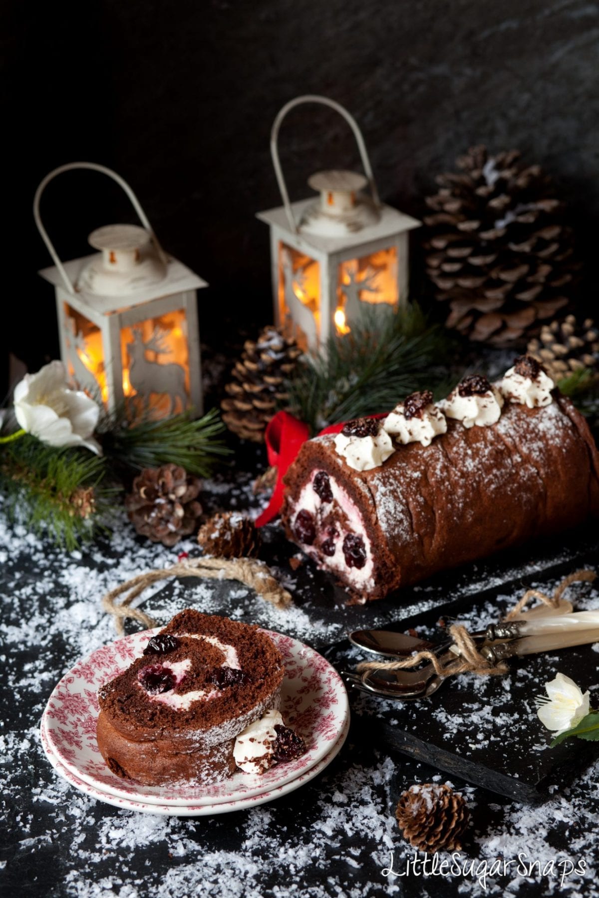 A slice of Black Forest Yule Log on small plates.