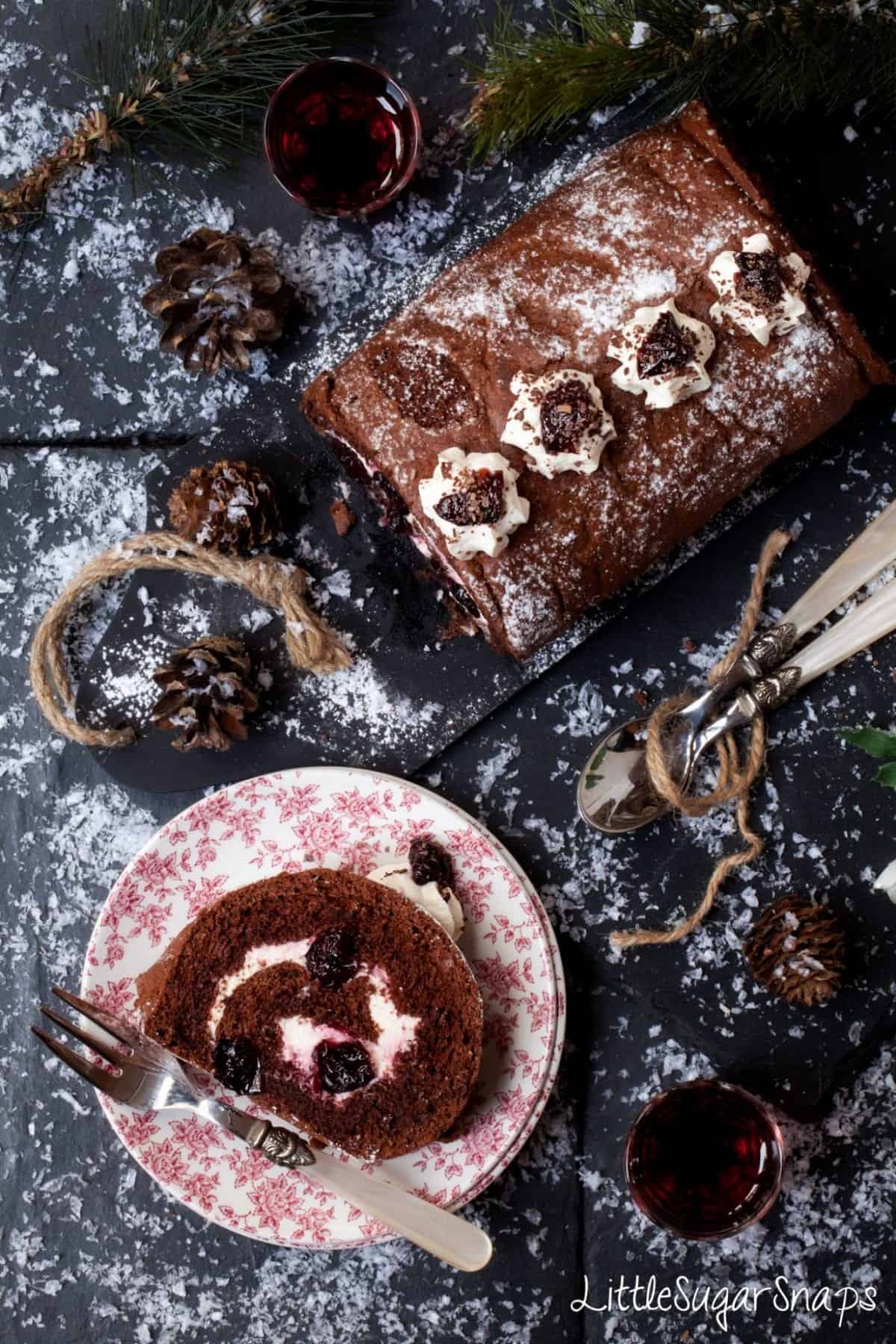 Black Forest Yule Log with a slice cut and presented on a small plate.