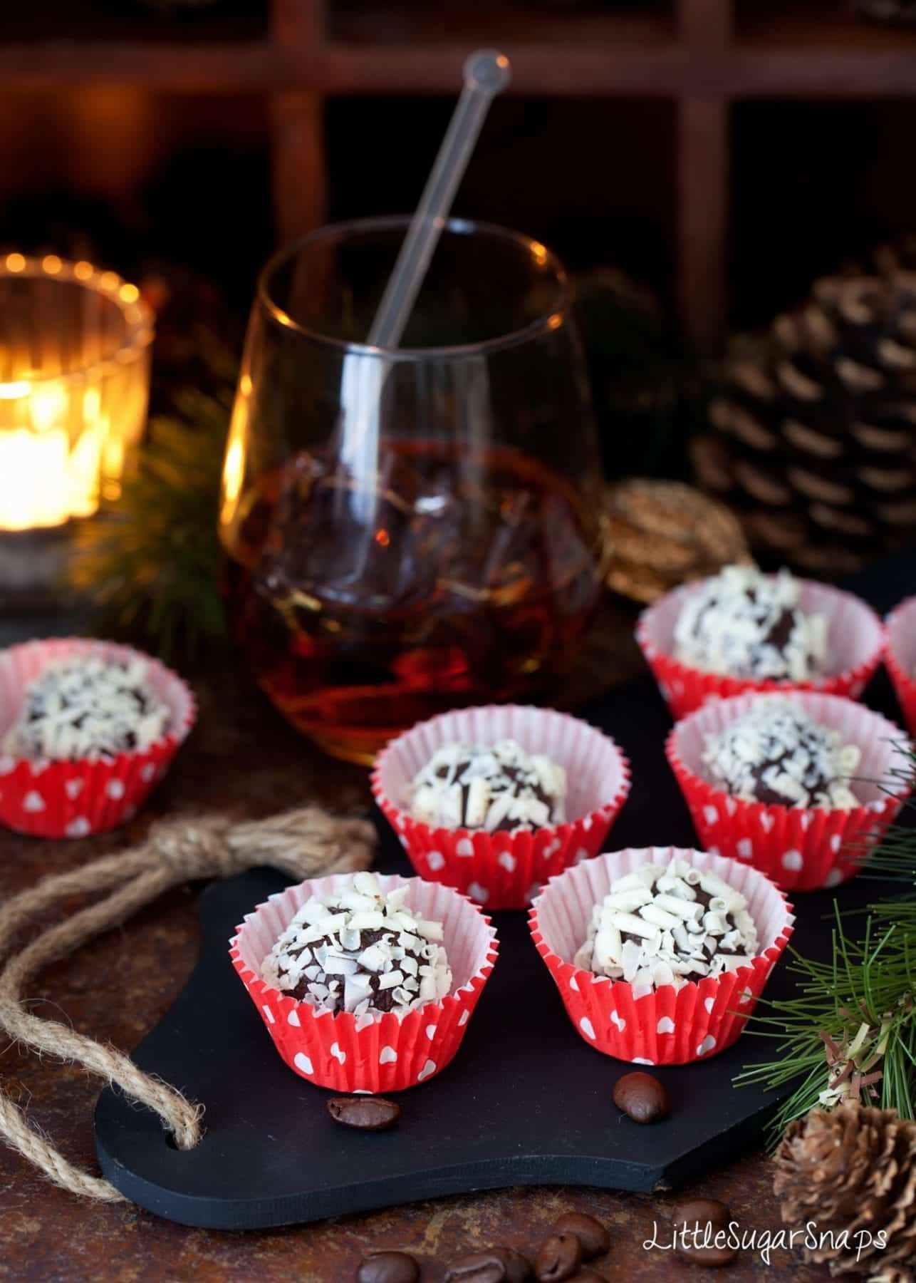 Black Russian Truffles in red paper cases with a black russian cocktail alongside,