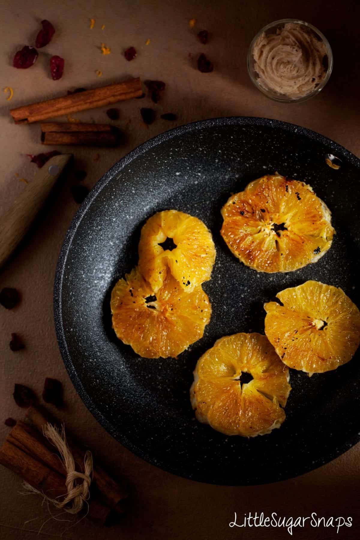 Orange slices in a pan after being cooked.