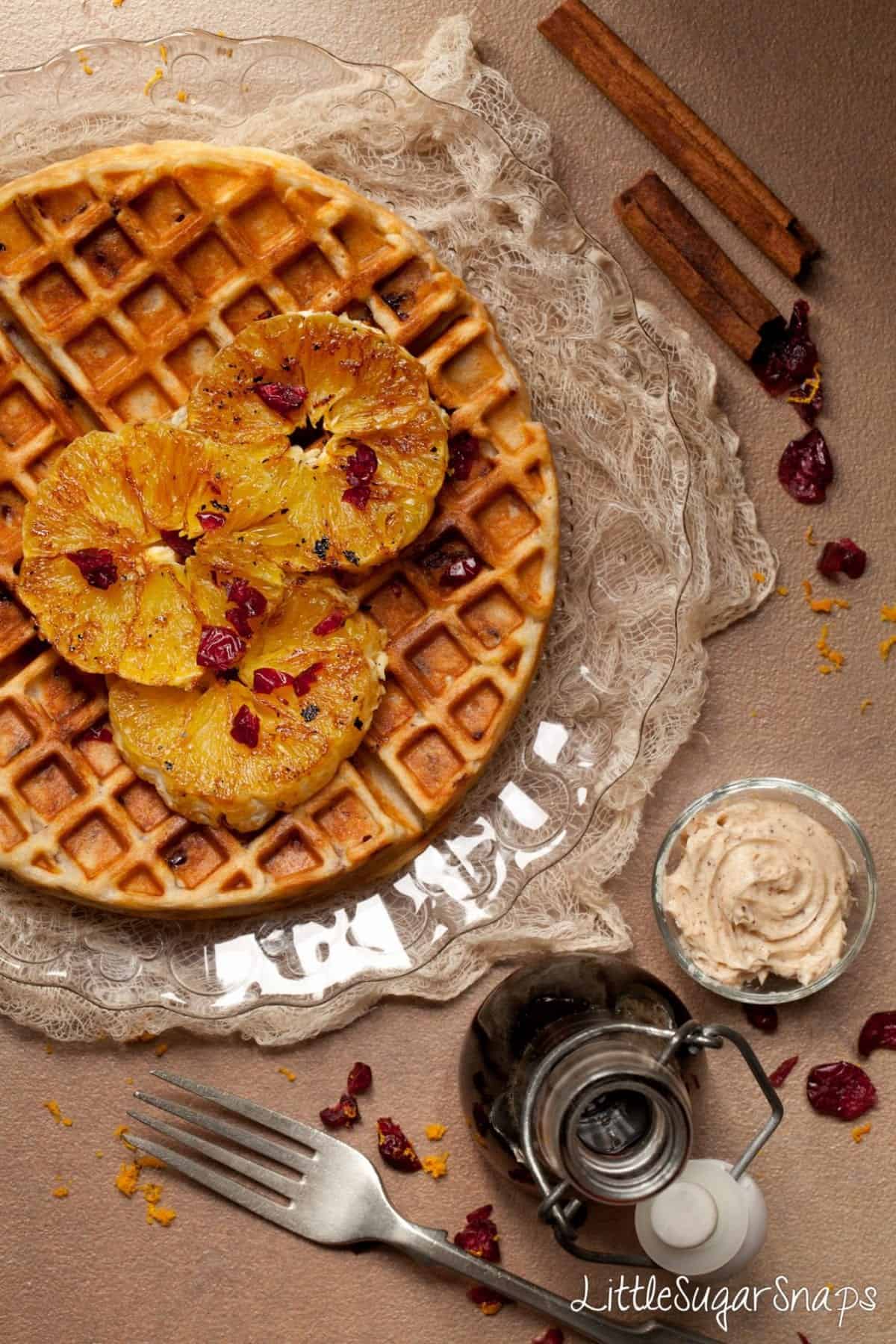 Waffles with Cranberry and charred Orange slices with cinnamon butter alongside.