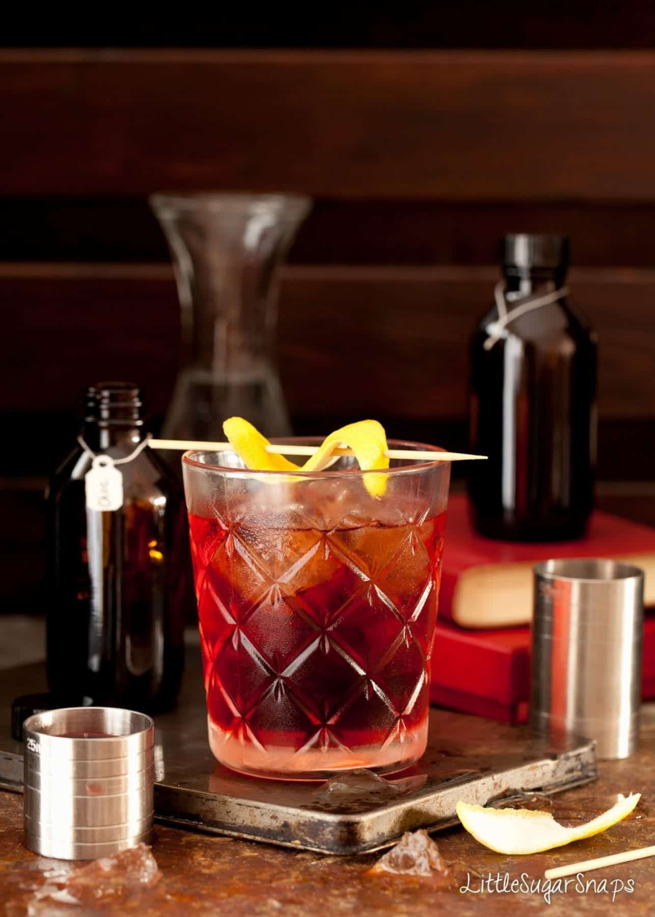 A classic negroni cocktail garnished with fresh lemon.