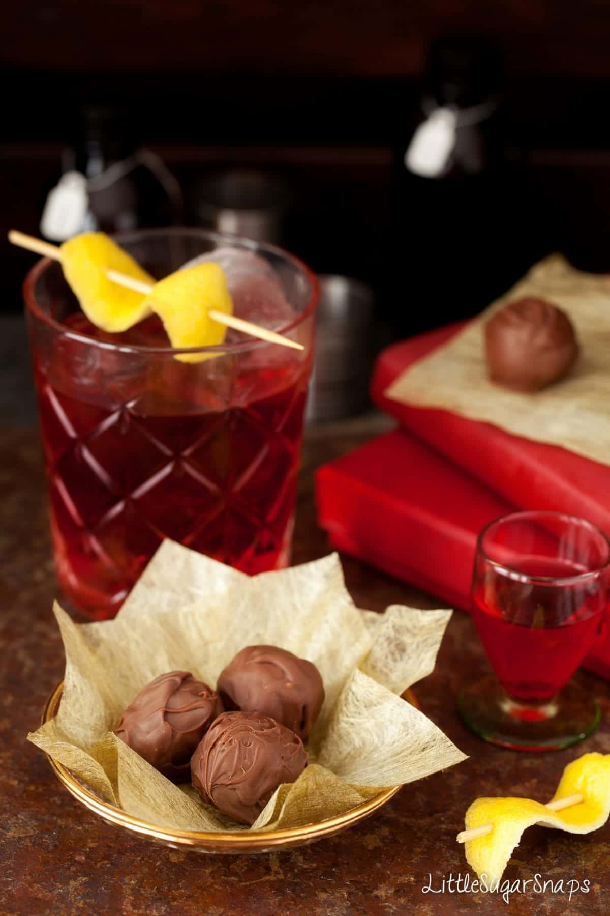 Negroni Truffles in front of a Negroni cocktail.