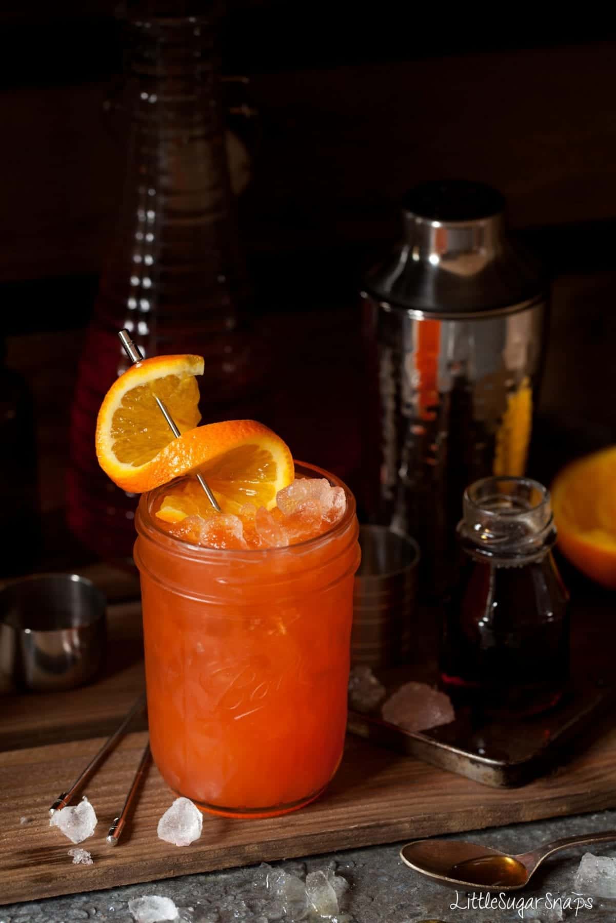 A tequila and Aperol cocktail garnished with a twist of orange.