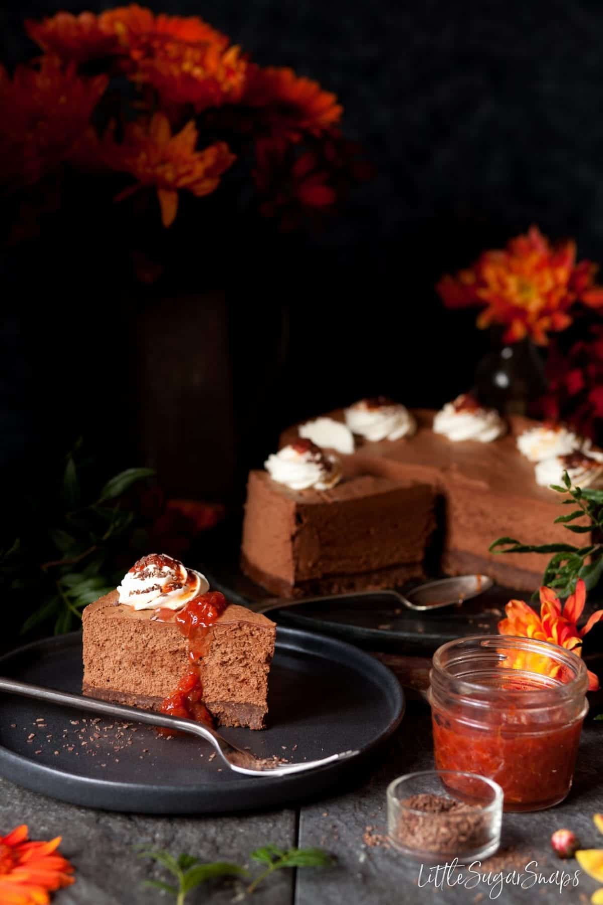 A slice of Cinnamon Chocolate Mousse Cake with cream and blood orange compote.