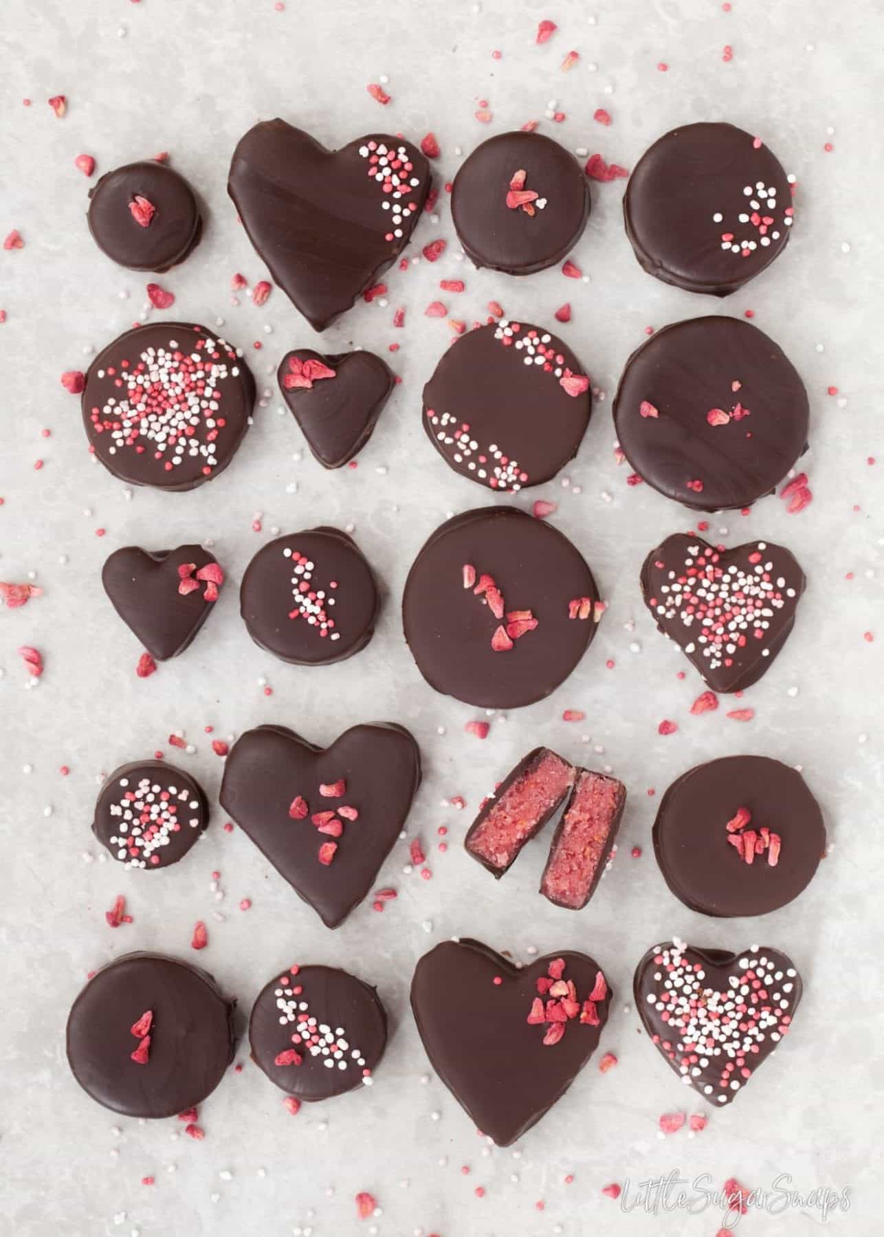 Pieces of chocolate covered Raspberry Marzipan with one cut in half.