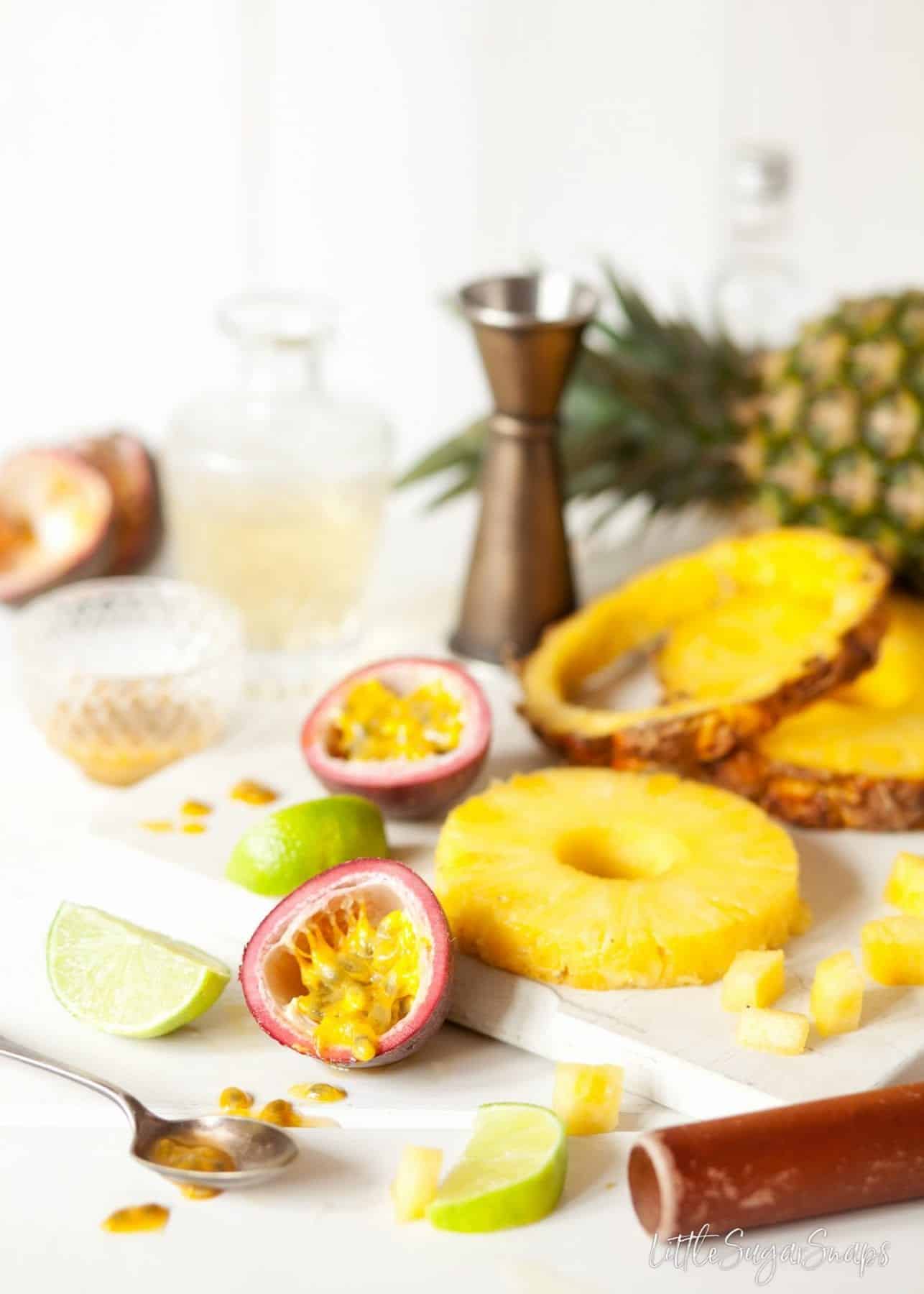 Ingredients on a chopping board: pineapple, passionfruit and lime.