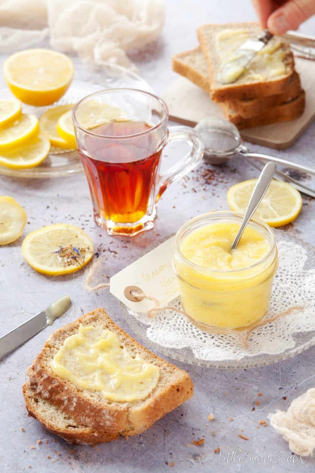 A pot of vanilla lemon curd with toast spread with curd alongside.