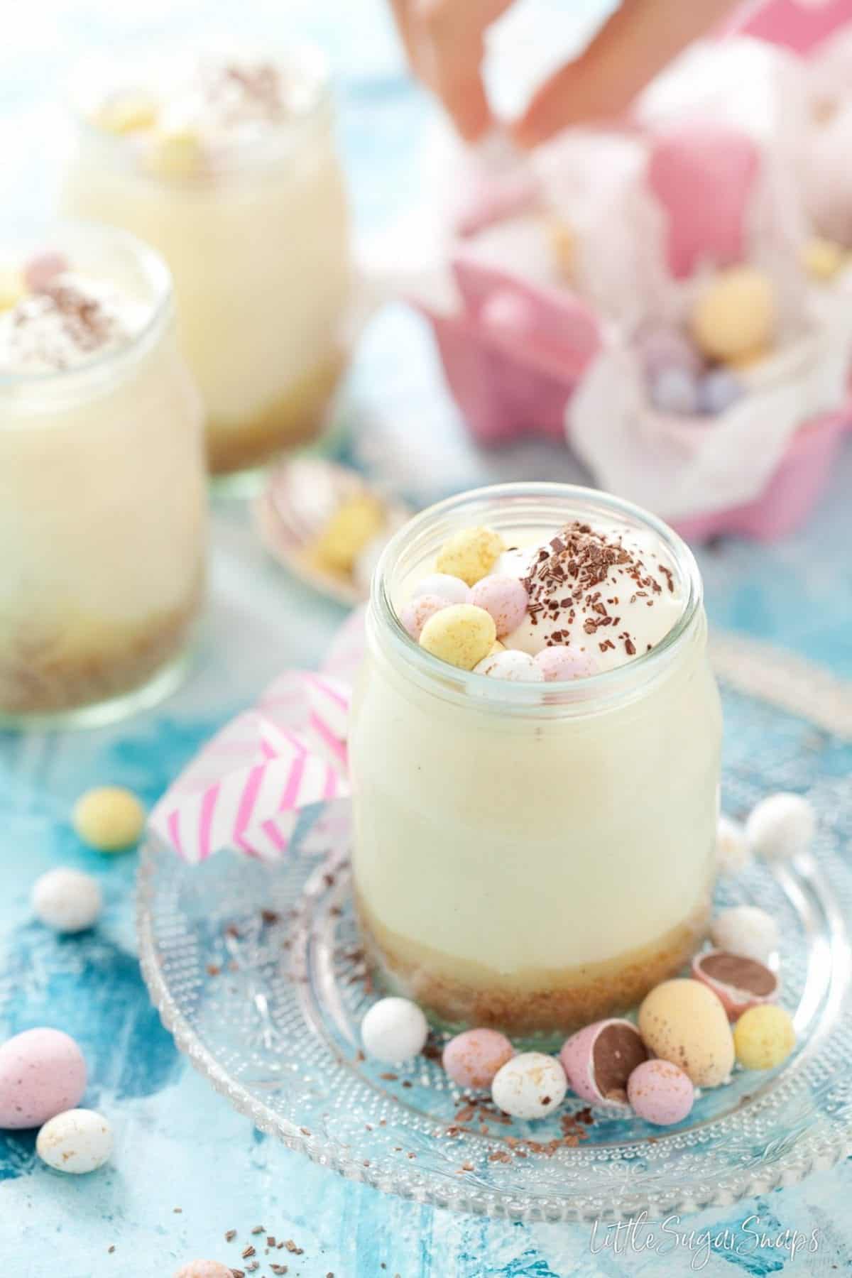 Pot of white chocolate mousse with lemon curd, cookie crumbs and mini eggs