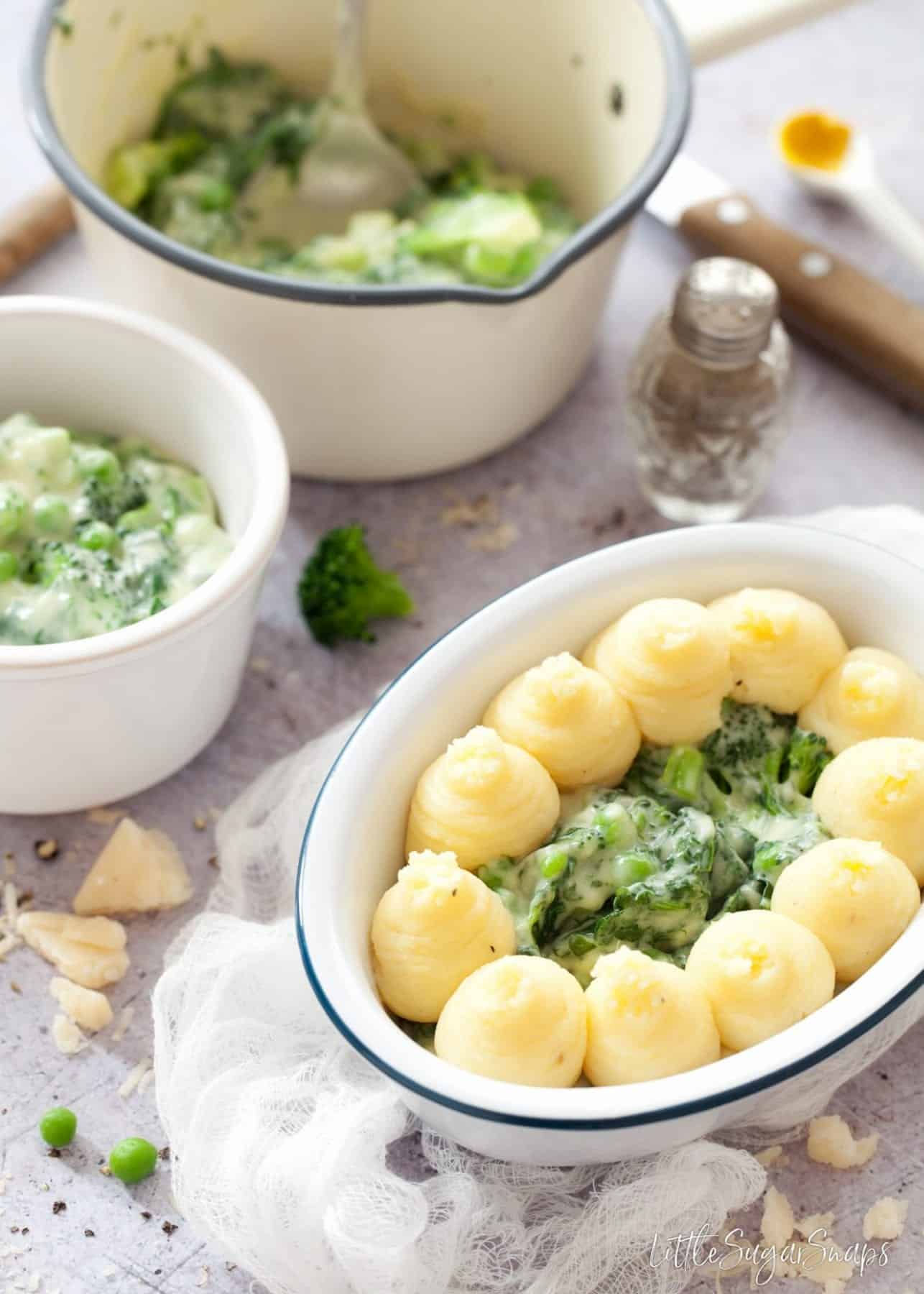 Assembling a vegetable pie - piping mashed potato on the top.