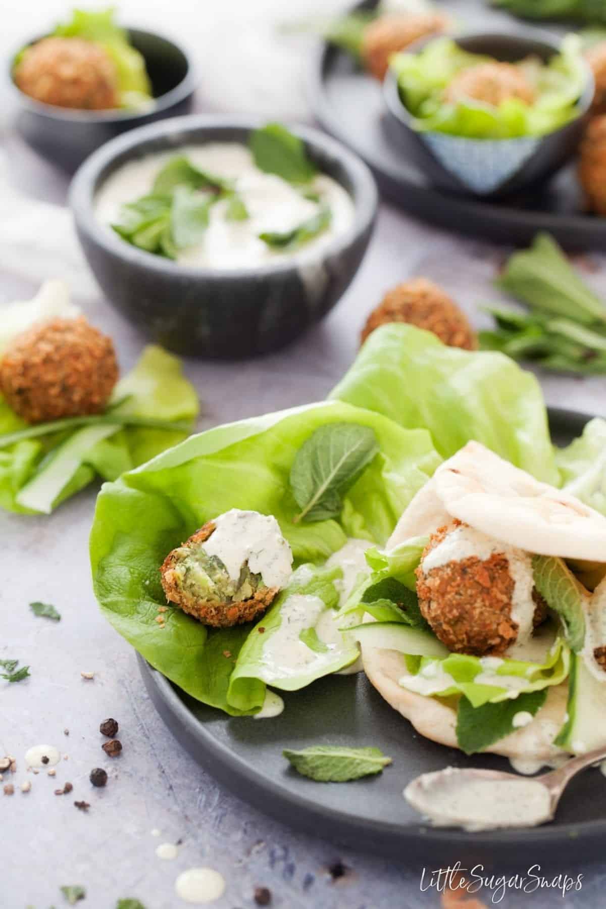 Mint Pea Falafel with lettuce, flatbread and dressing.