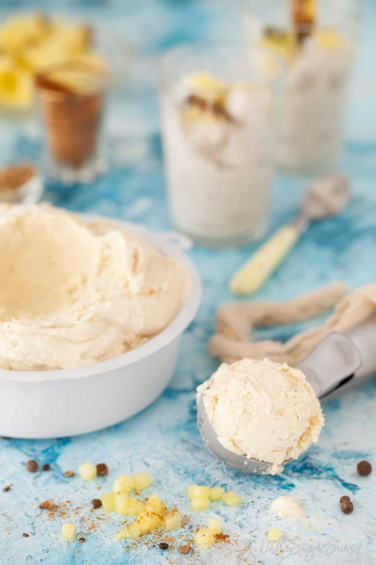 Pineapple flavoured icecream being scooped from a tub.