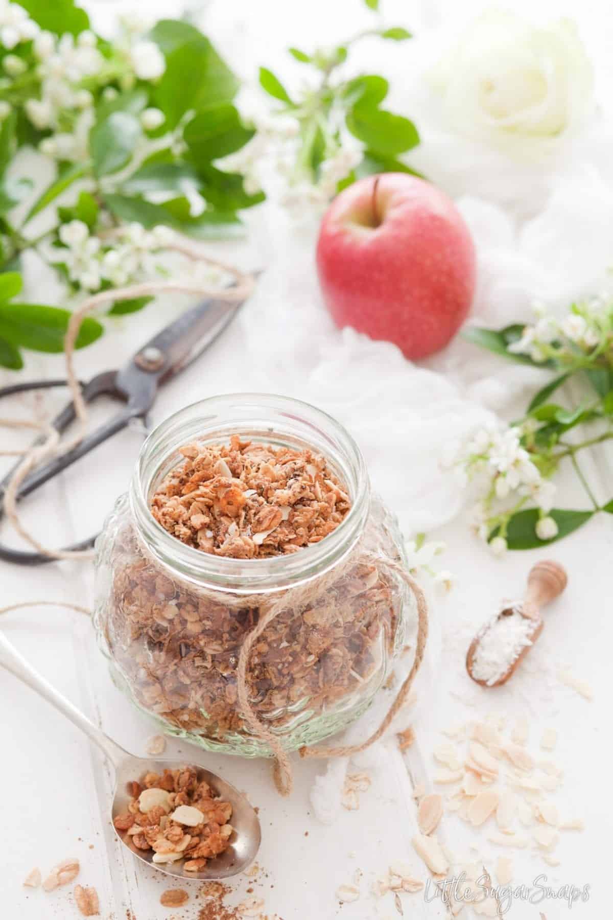 A jar of Apple Granola with ingredients alongside.