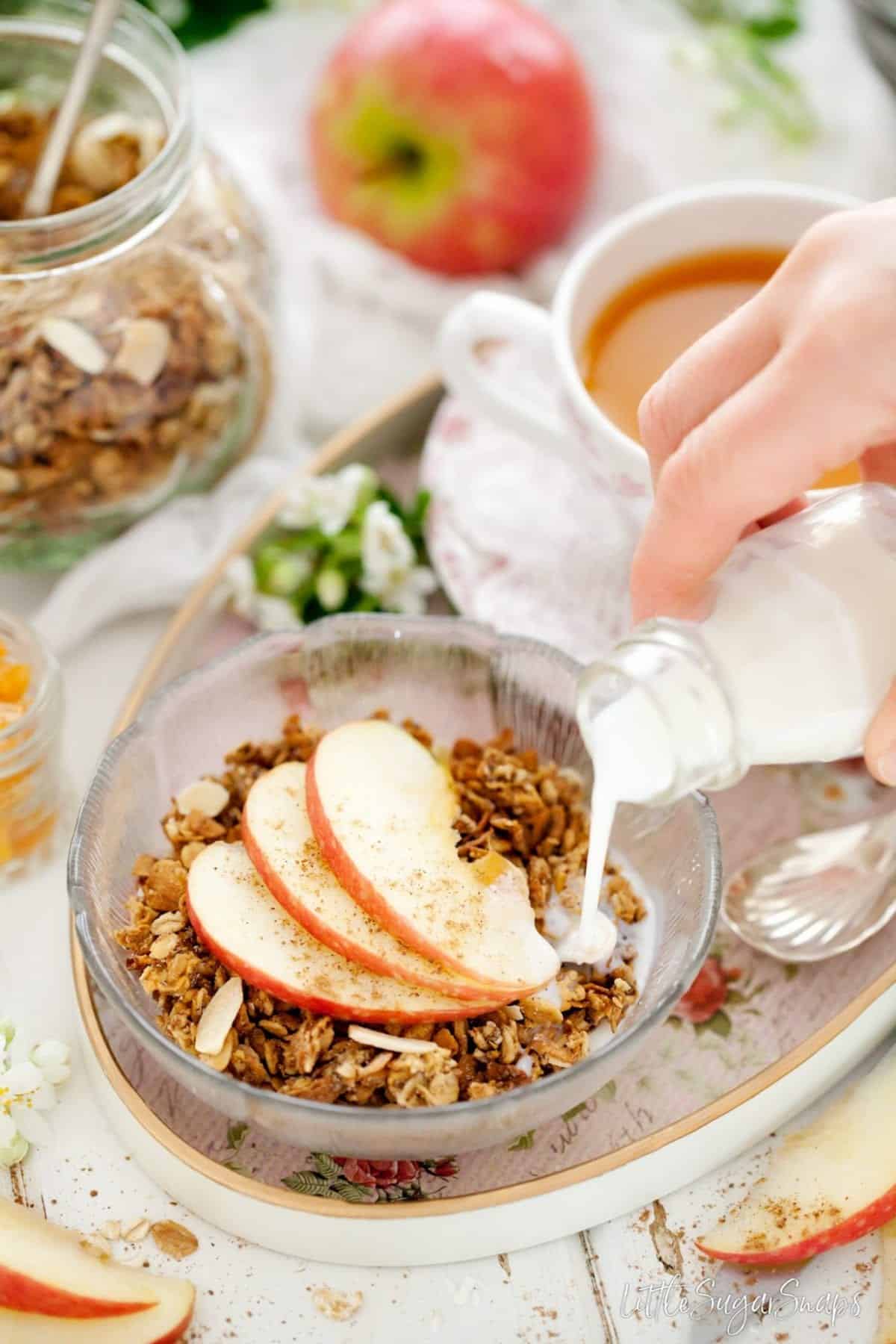 Person pouring milk into a bowl of breakfast cereal.