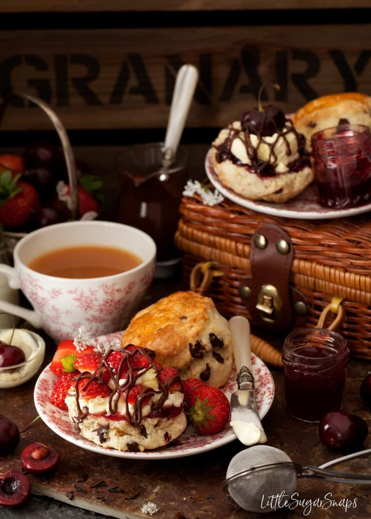 Chocolate chip scones served with strawberries, cream and chocolate sauce.