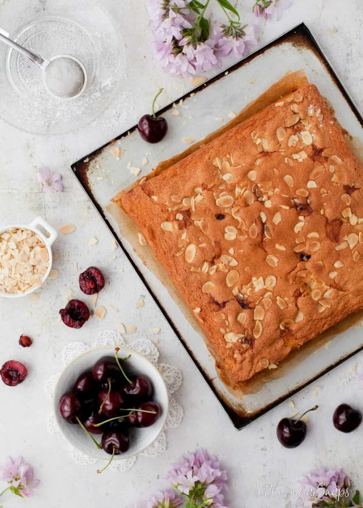 Cherry and Almond Traybake cake on a baking sheet before being cut up.