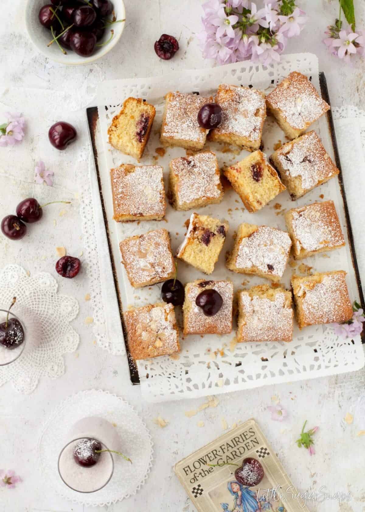 Gluten Free Cherry Almond Traybake cut into squares on a baking sheet.