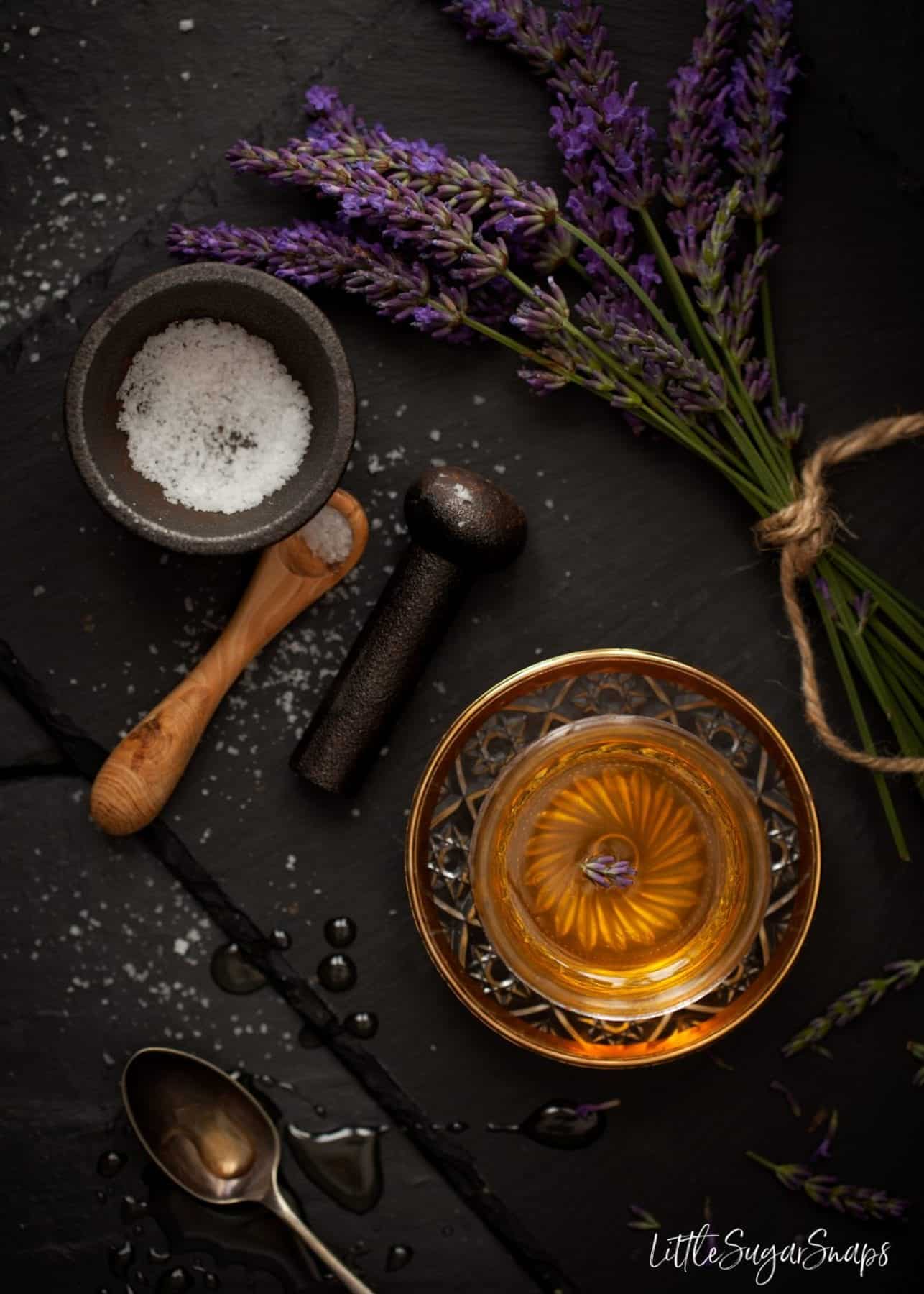 Honey and sea salt in pots alongside fresh lavender.