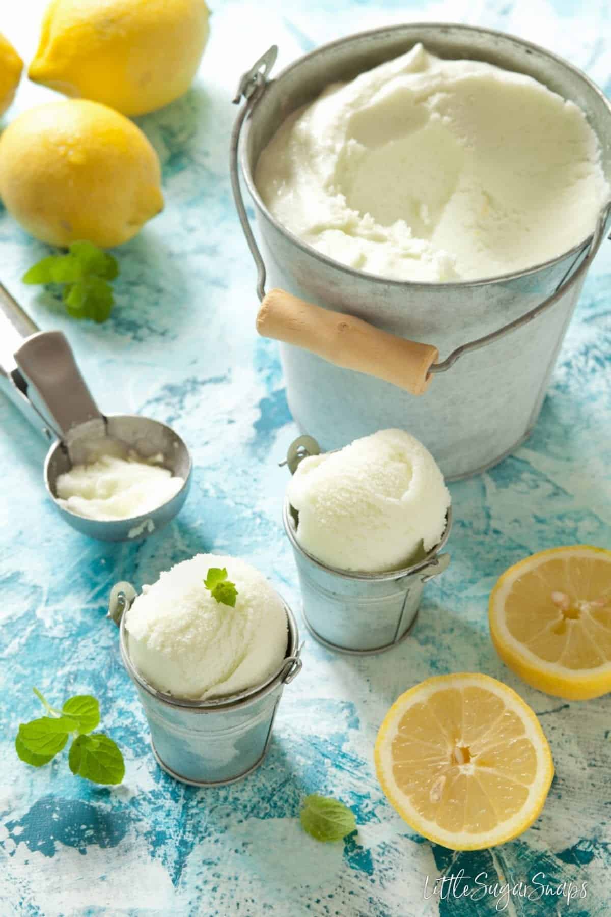 Limoncello Lemon Sorbet scooped from a big bucket into mini buckets for serving. 