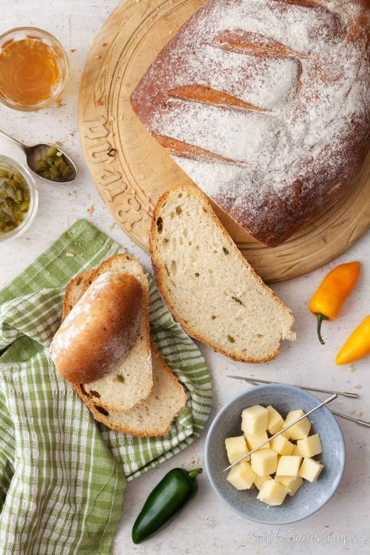 Part sliced loaf of jalapeño cheddar bread with ingredients alongside