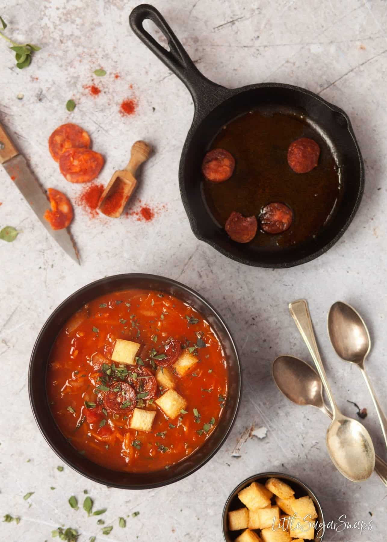 Hearty Paprika Soup with Carrot and Zucchini garnished with fried chorizo slices