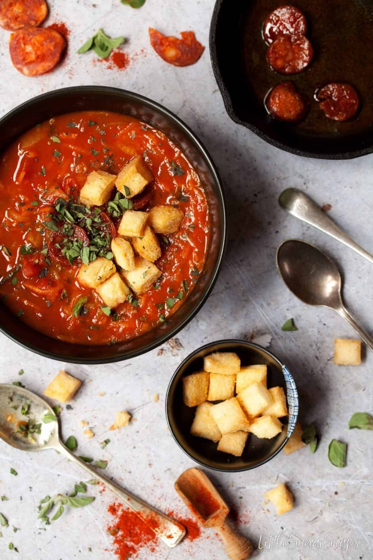 Tomato, Carrot and courgette soup in a bowl with croutons and fresh oregano