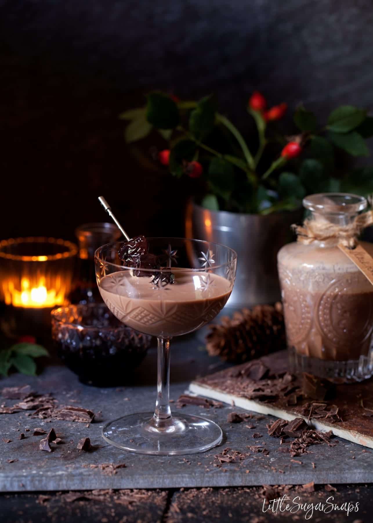 Cherry chocolate liqueur in a vintage cocktail glass with an edible garnish on a cocktail pick. 