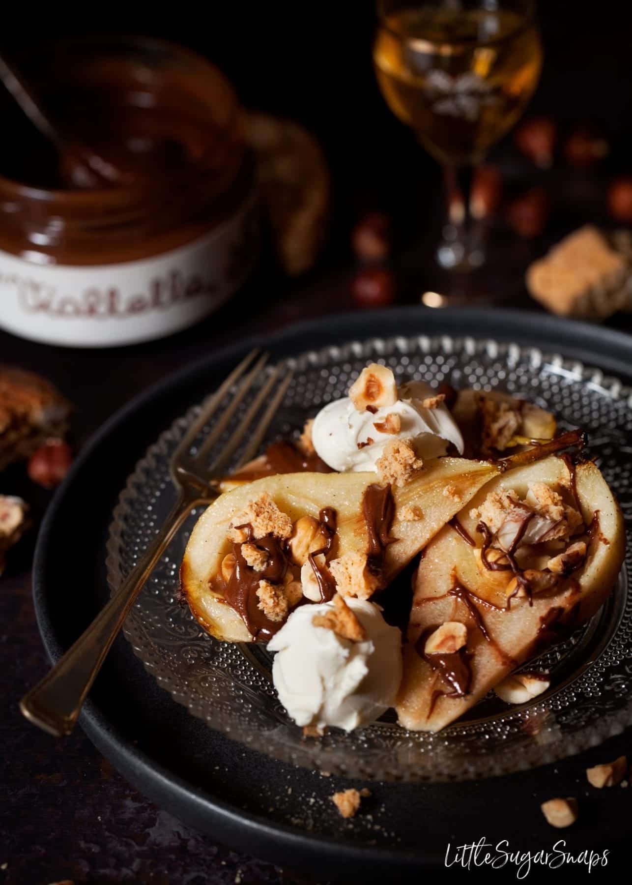 Baked Pears with Chocolate, hazelnuts and cookies served on a plate with mascarpone cream cheese