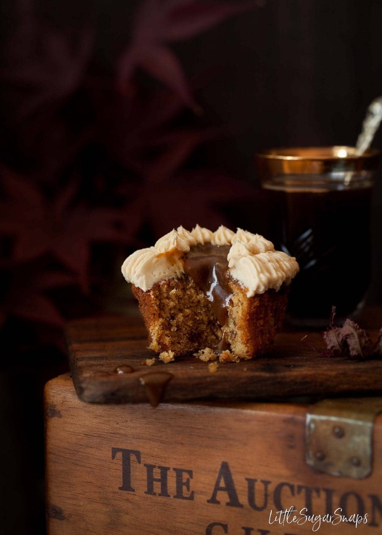 Sticky Toffee Cupcake cut open with sauce running down the inside. 