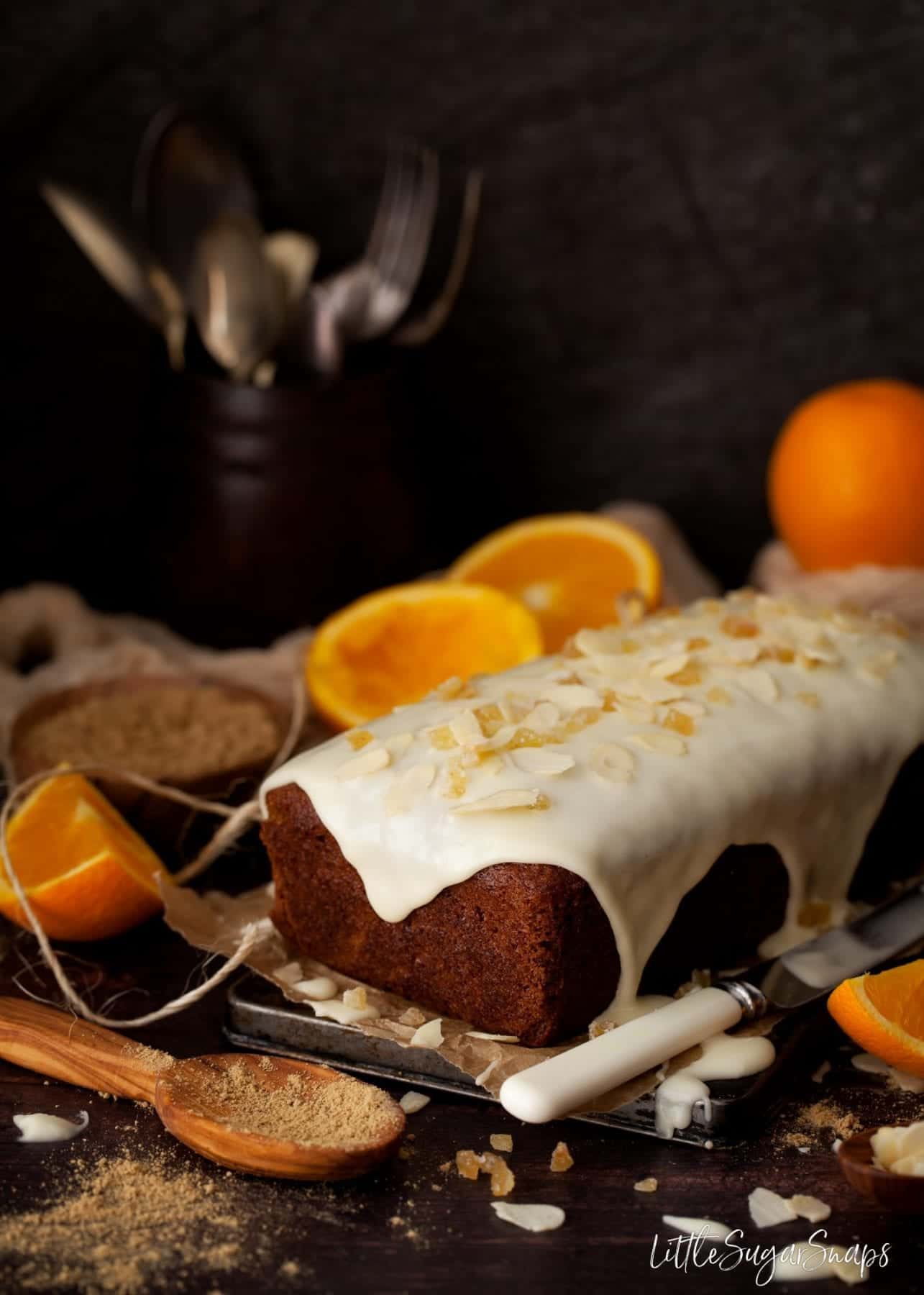 Vegan ginger cake with orange icing and crystalised ginger on top.