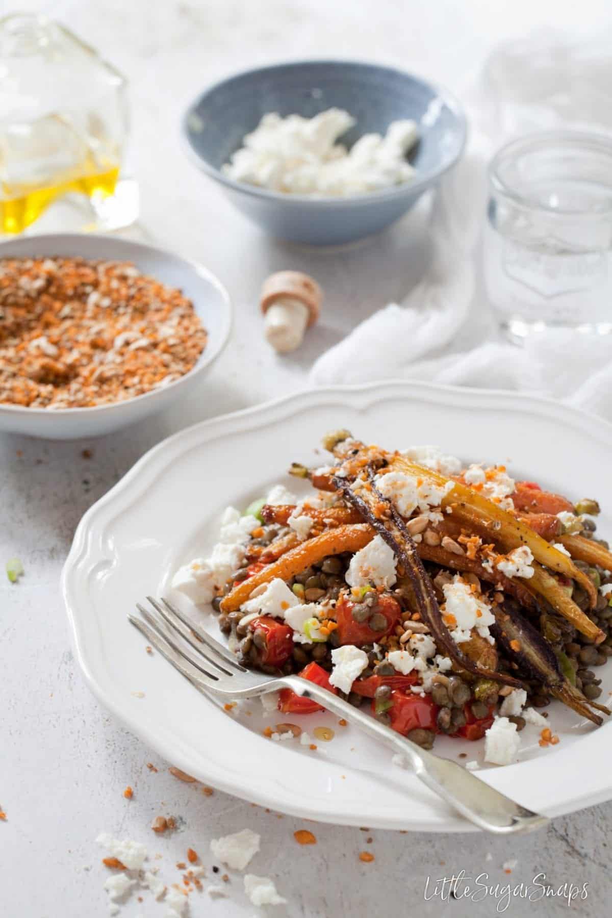 A plate of Roast Carrot and Lentil Salad topped with feta and dukkah.