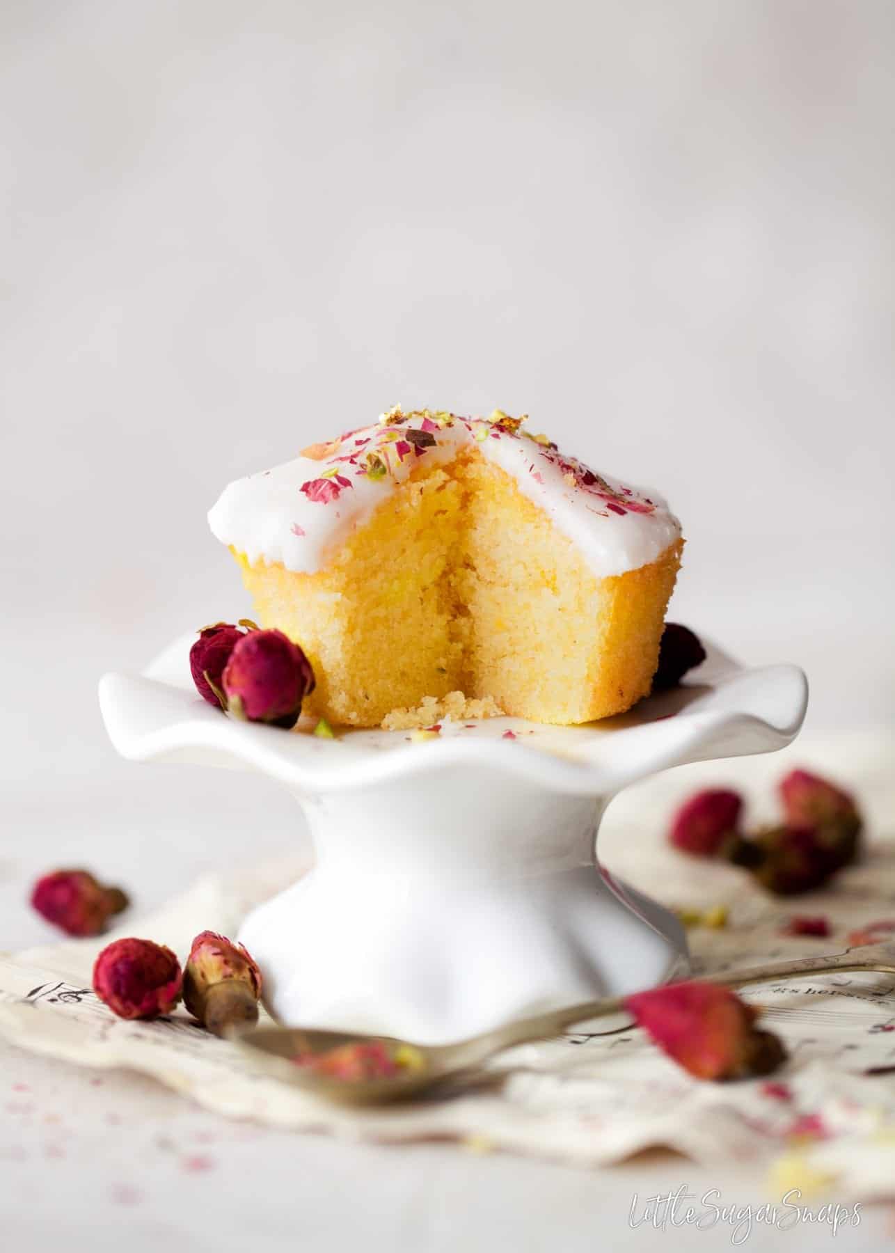 A cupcake version of persian love cake on a small stand (cake is cut open)