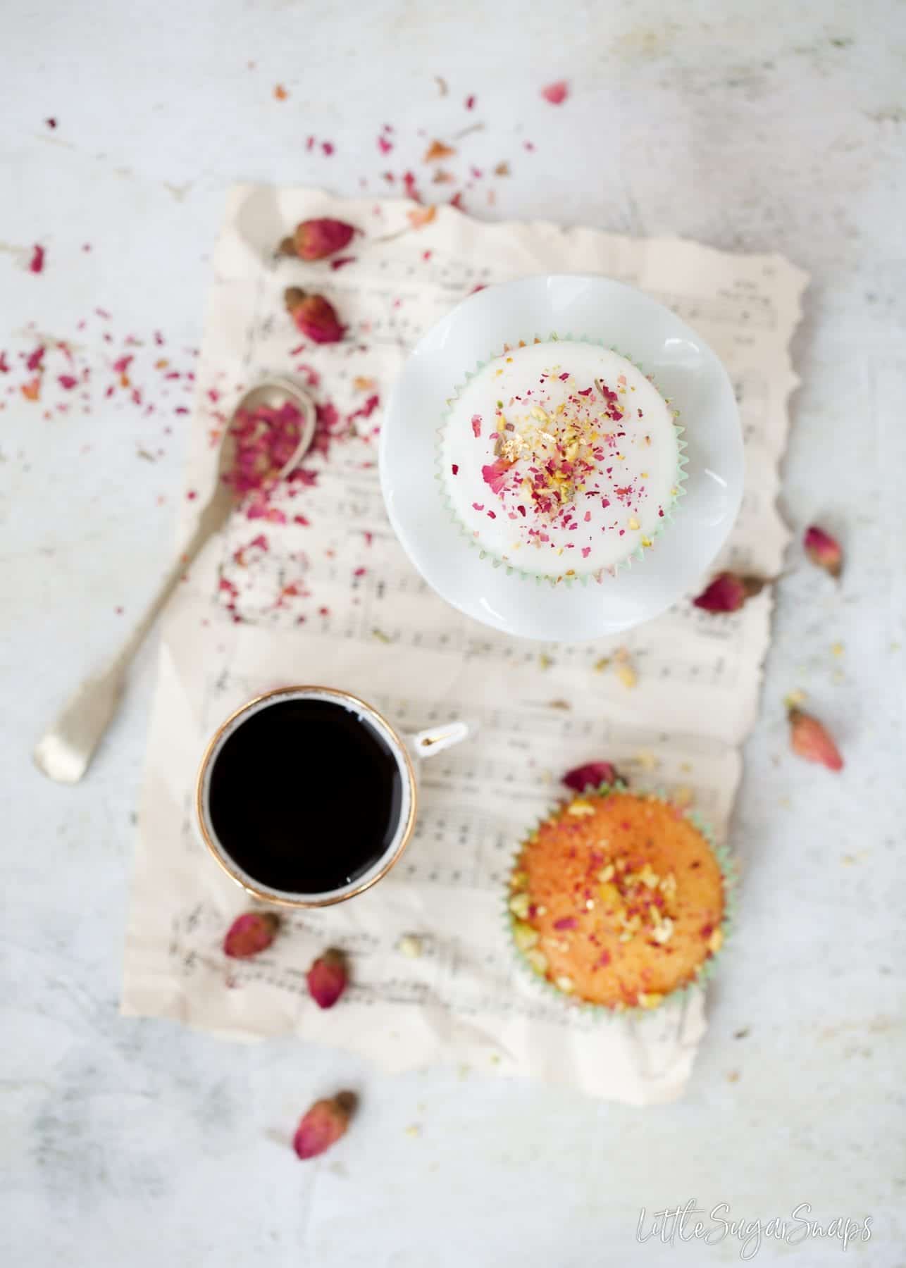 A cup of black coffee with small cakes.