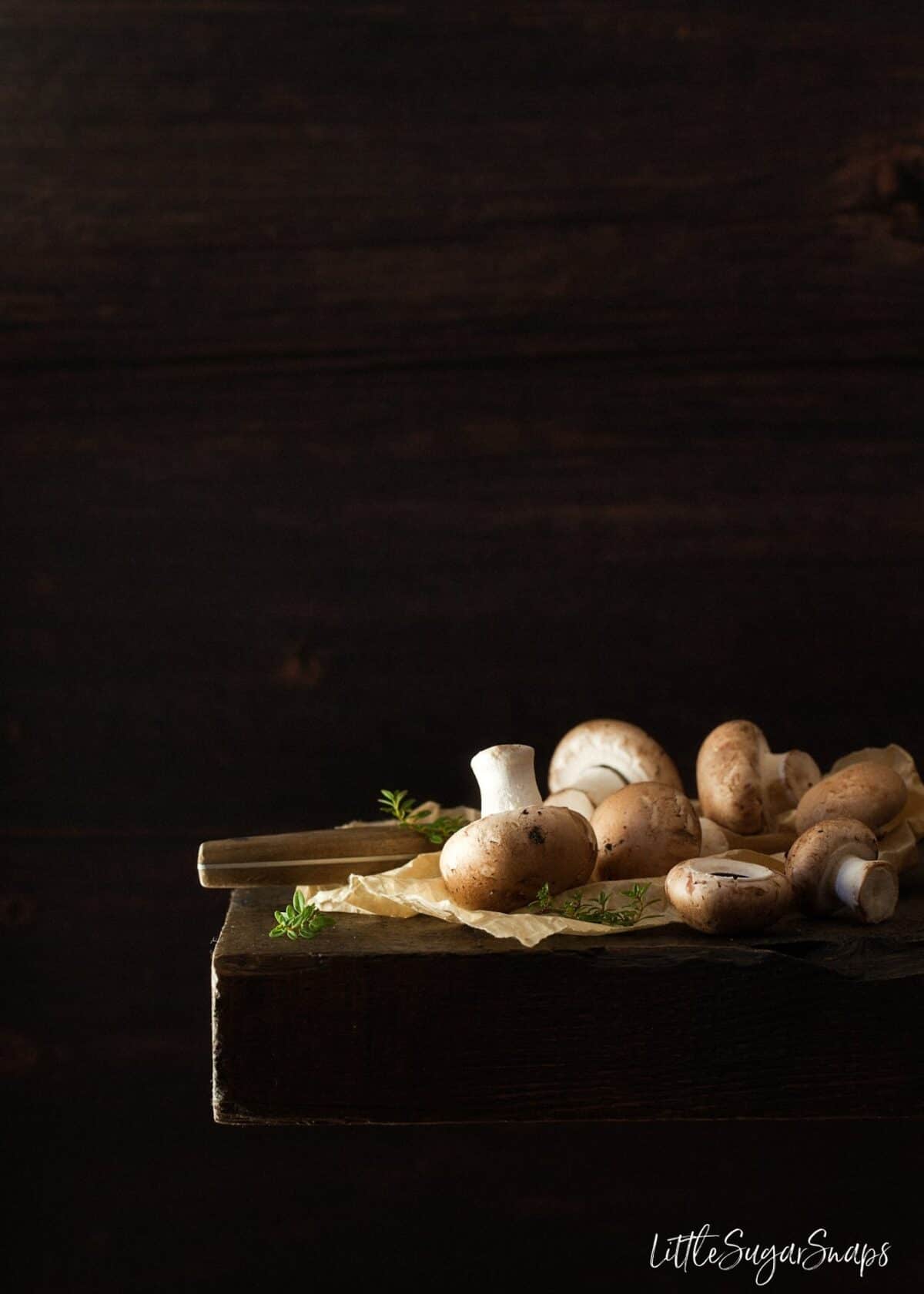 Chestnut mushrooms on a wooden board.