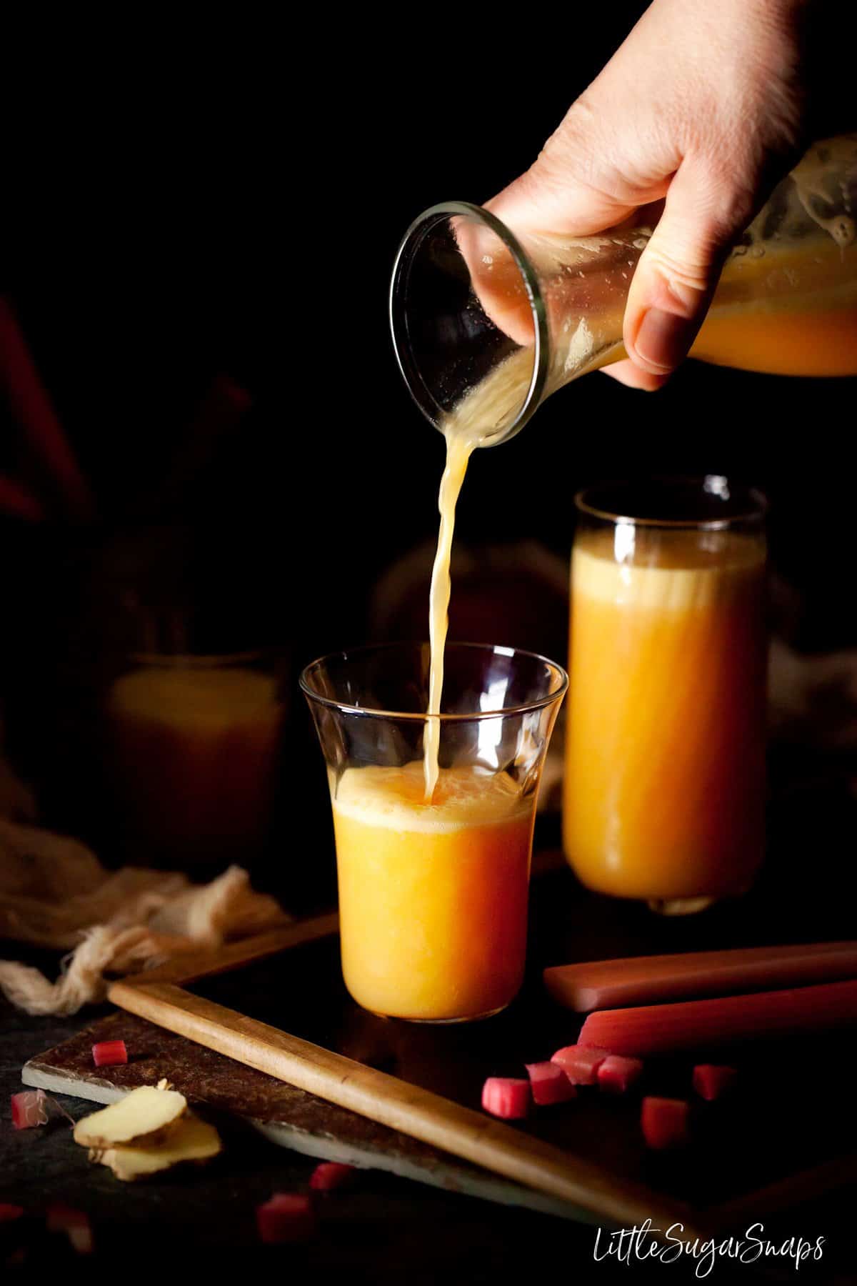 Rhubarb Juice with Ginger Orange & Apple being poured into a glass. 