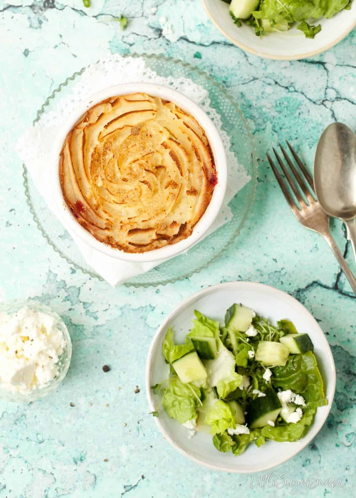 Potato topped pie with a plate of green salad.