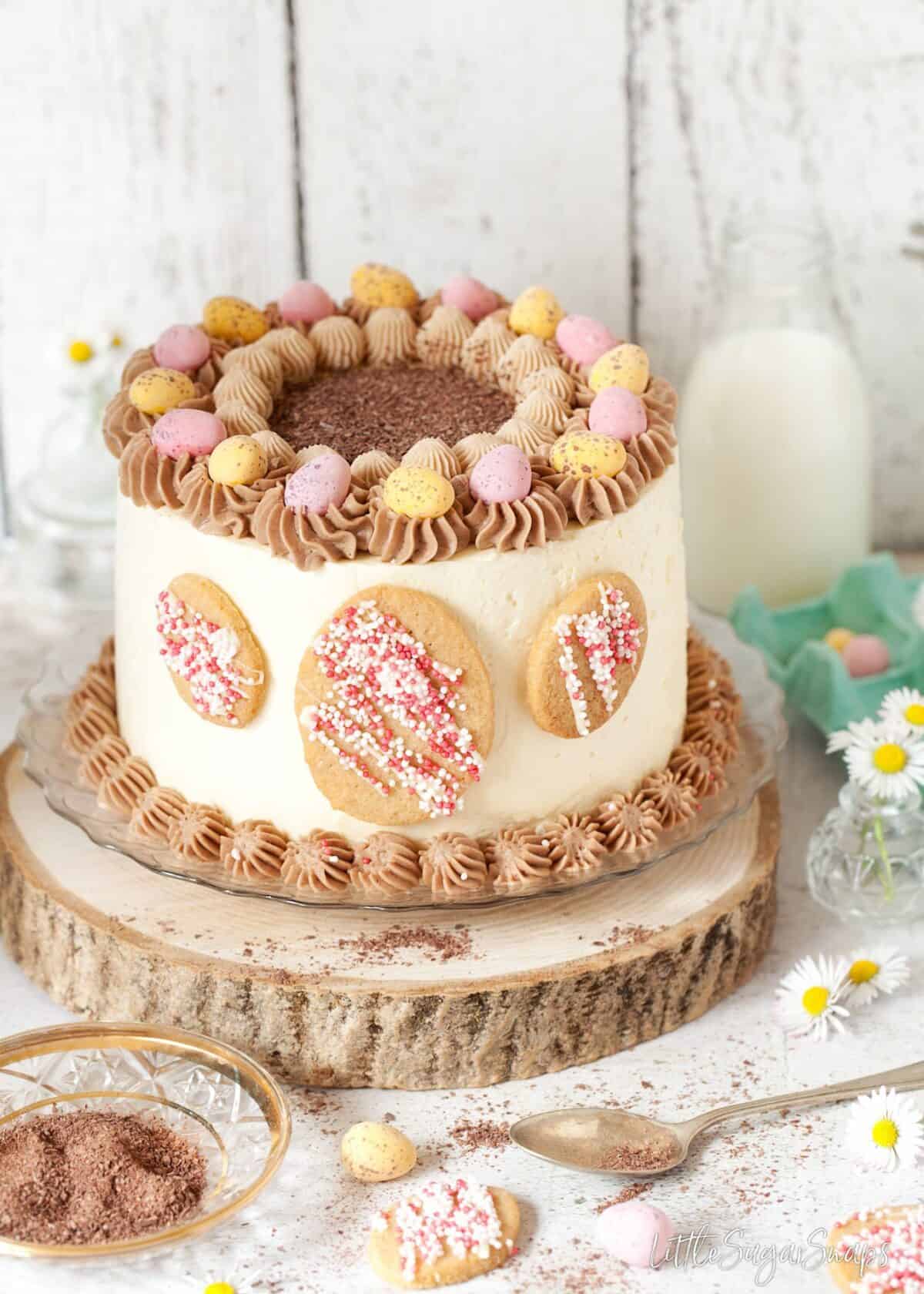 Layer cake decorated with mini eggs and egg shaped cookies.