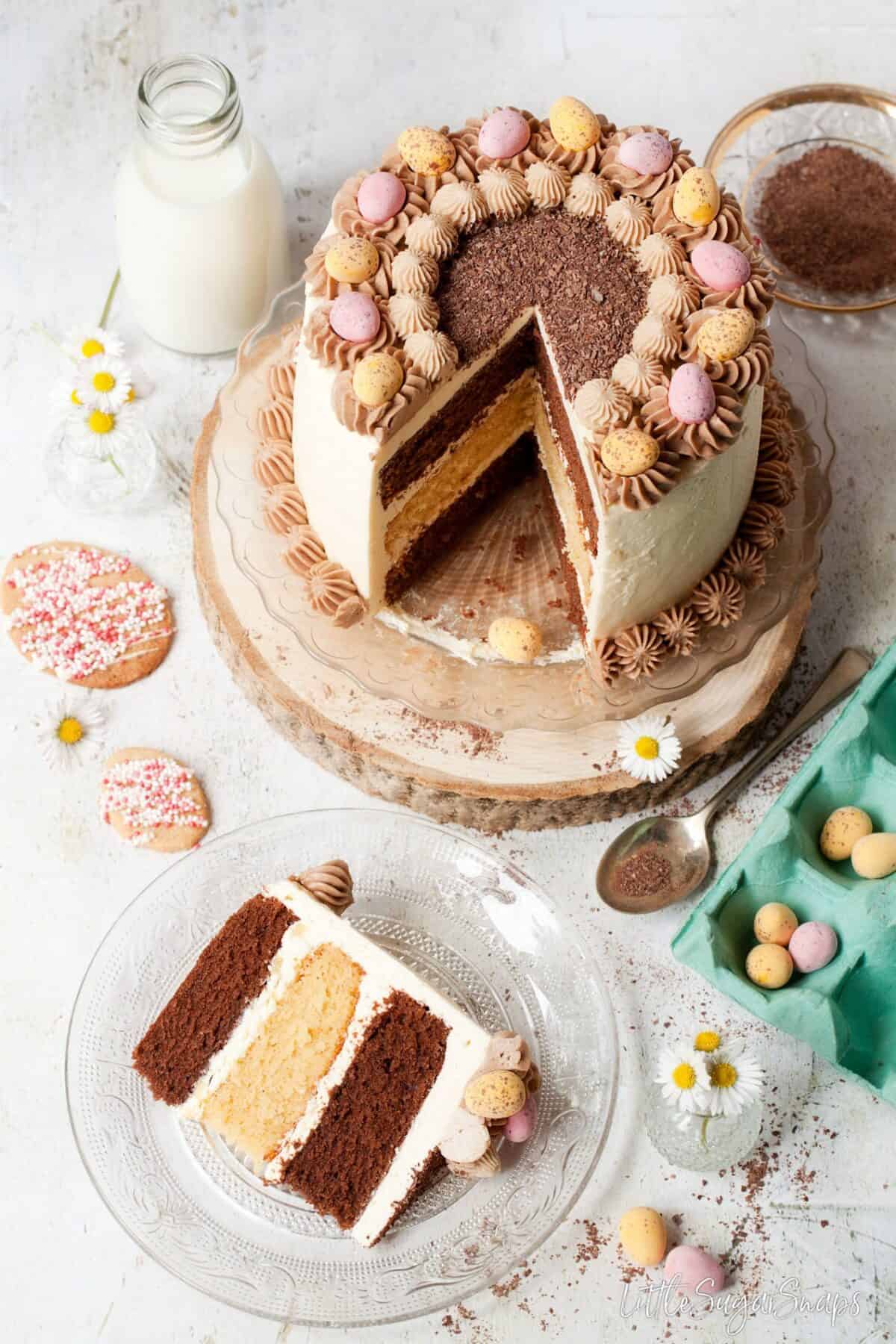 chocolate and vanilla cake with a slice cut on out a glass plate.