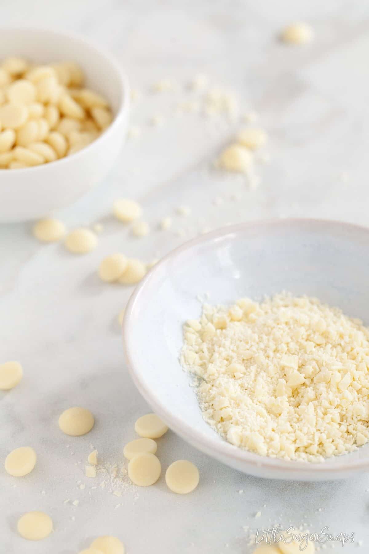 White chocolate chips, some in a bowl finely chopped reading for tempering