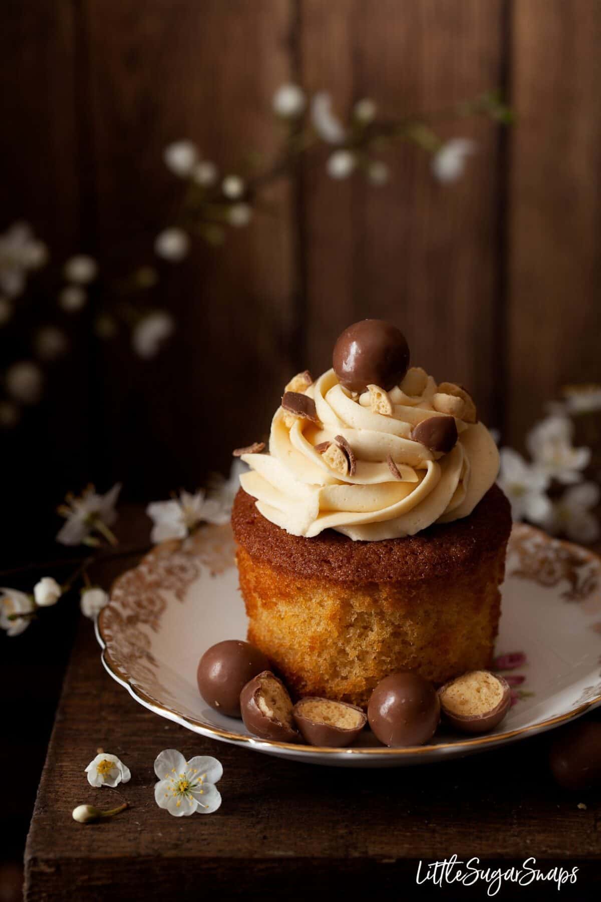 A buttercream topped cupcake out of its baking wrapper.