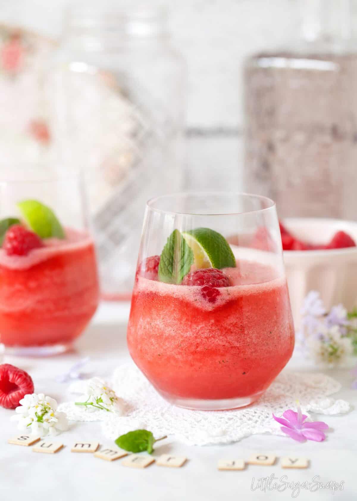 Raspberry and mint flavoured frozen gin & tonics with letter tiles spelling summer joy