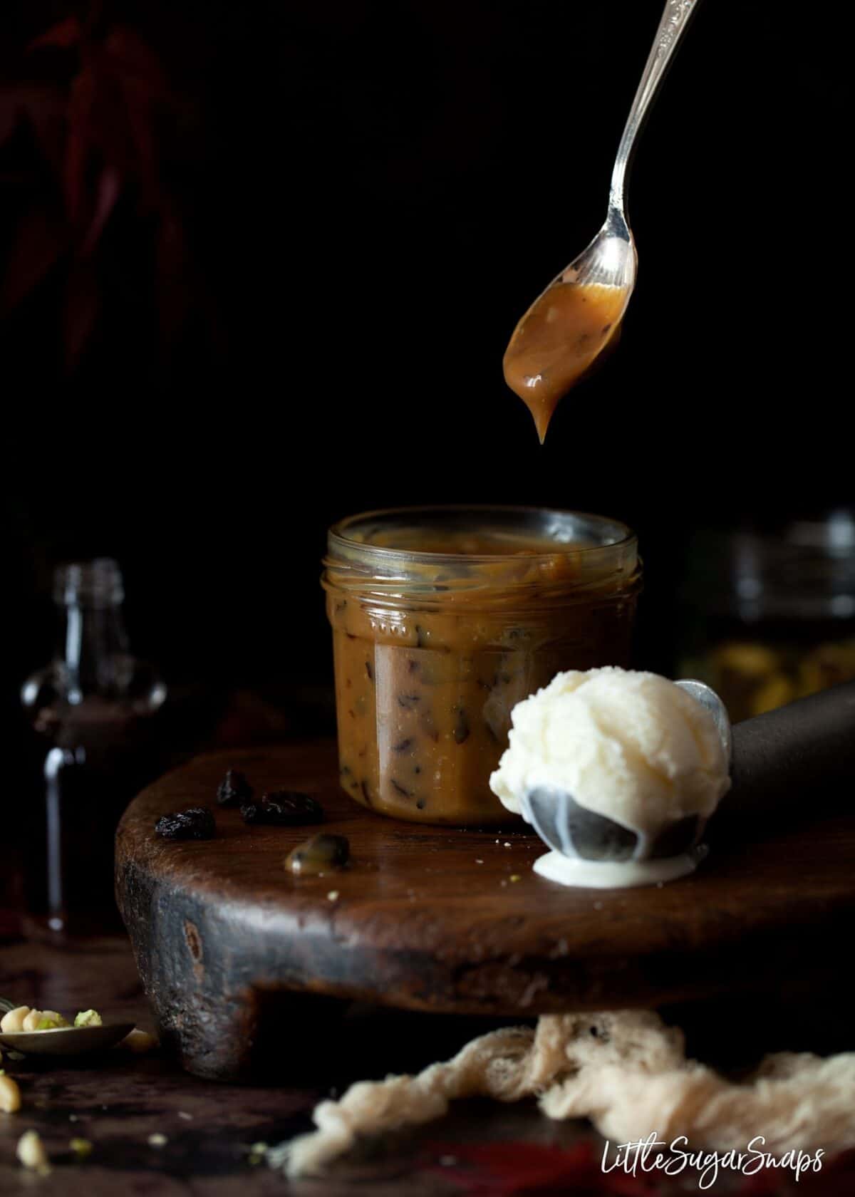 Rum & raisin caramel sauce being served with vanilla ice cream