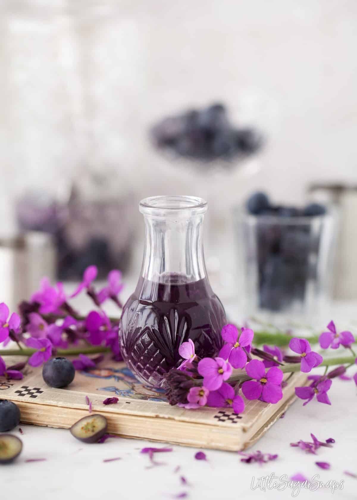 Violet liqueur with blueberries and purple flowers