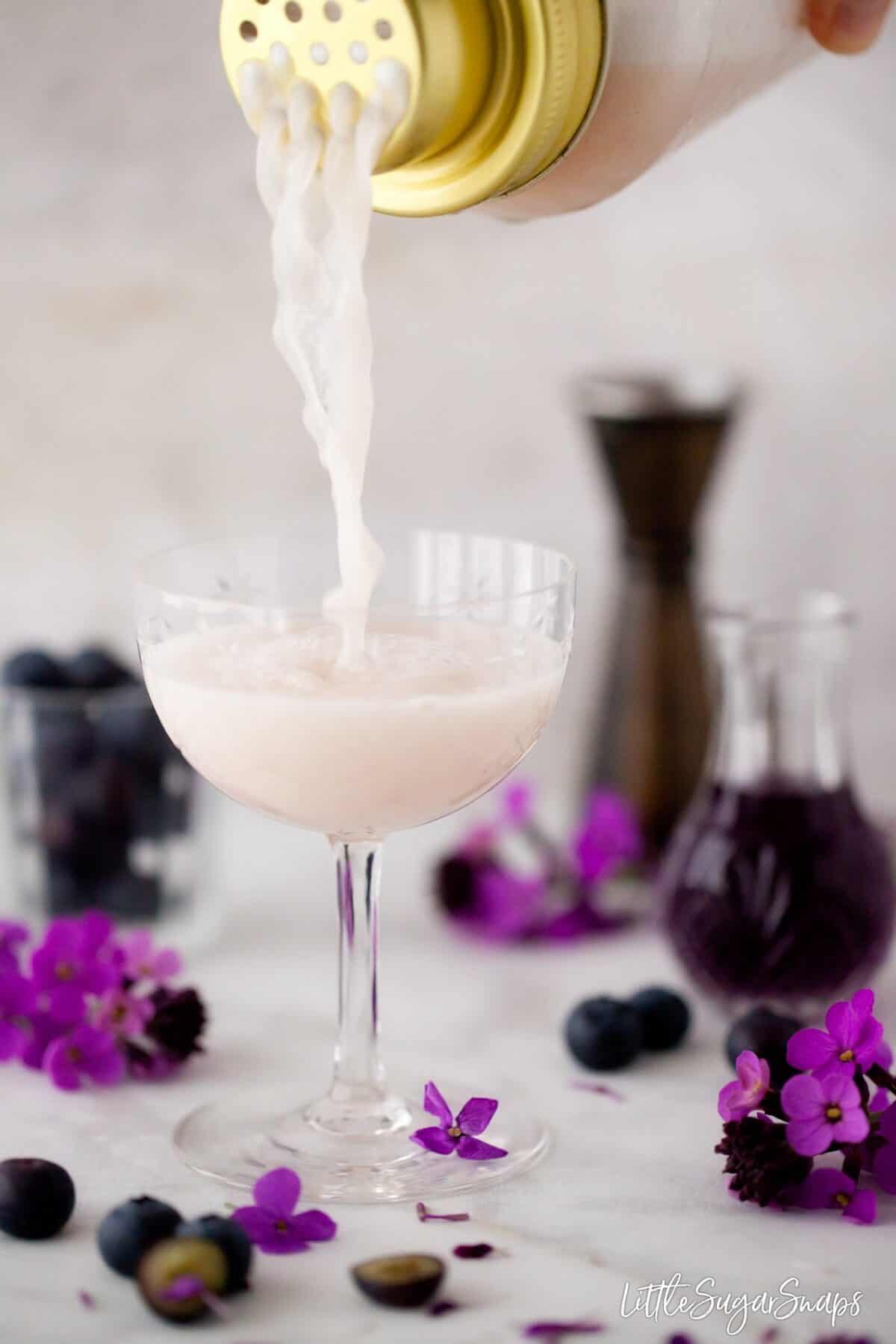 Violet Blueberry Gin Sour cocktail being poured into a glass